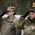 20th anniversary of NATO expansion Two military officers are saluting during what appears to be a formal ceremony. The officer on the left wears a U.S. Army uniform with the name tape 'BISSELL' and a two-star general rank insignia, while the officer on the right wears a Hungarian Army uniform with the name tape 'HORVEN' and a green beret. The setting appears to be an outdoor military event, possibly in Poland based on the partial text 'WEJHERO' visible in the background.
