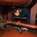 Sailor Cleans Bilge in Engineering Space Aboard USS Harpers Ferry (LSD 49).