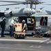 U.S. Sailors load cargo into an MH-60S Sea Hawk