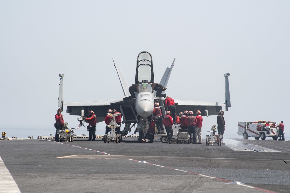 U.S. Sailors tend to an F/A-18E Super Hornet assigned to Strike Fighter Squadron (VFA) 97