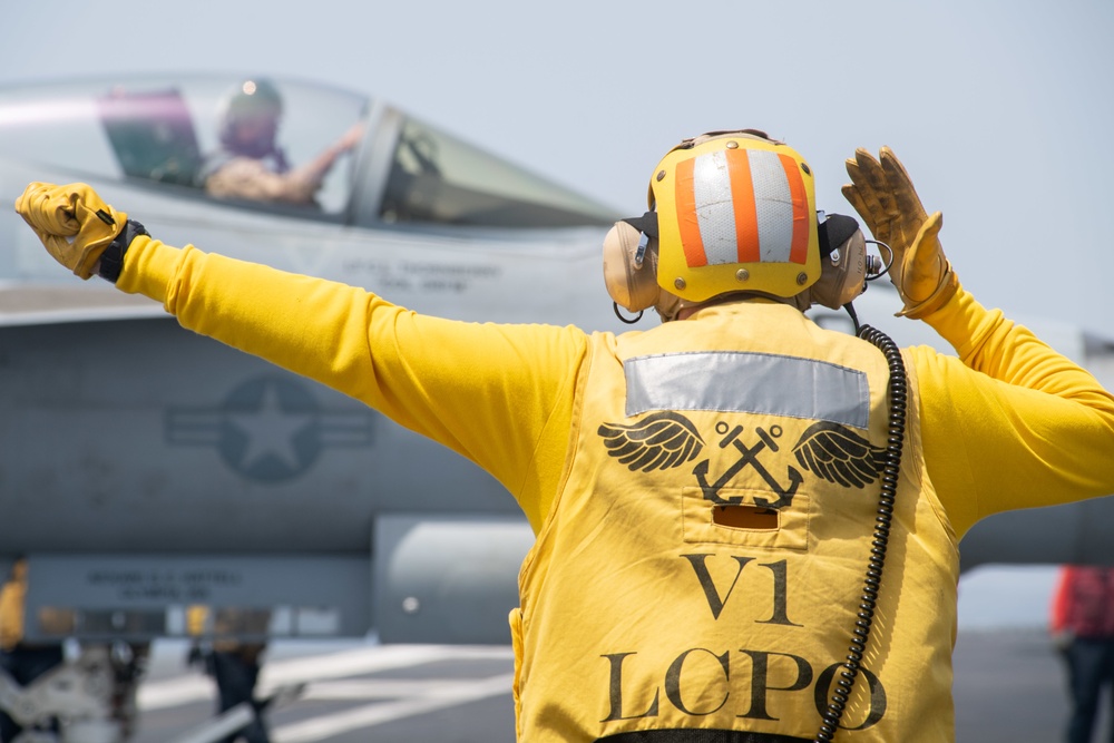 U.S. Sailor directs an F/A-18E Super Hornet assigned to Strike Fighter Squadron (VFA) 97