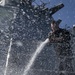 Sailor hoses down the exterior of the USS Carney (DDG 64)