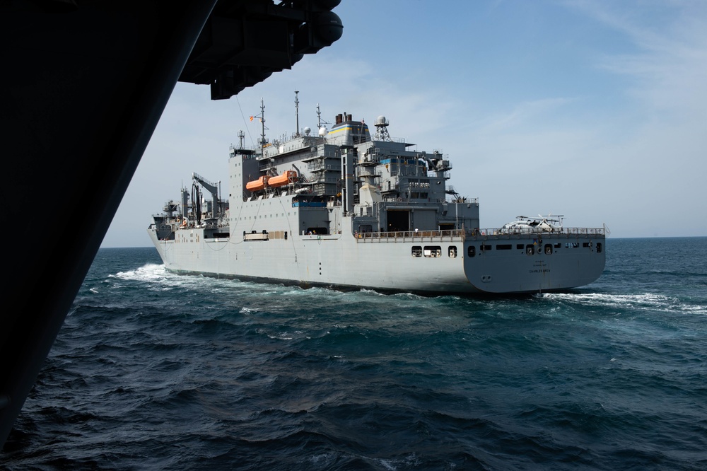 The dry cargo and ammunition ship USNS Charles Drew (T-AKE 10) steams alongside the aircraft carrier USS John C. Stennis (CVN 74)