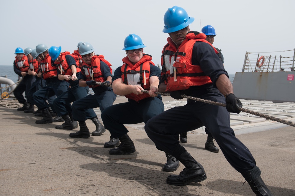 U.S. Sailors heave around on a line aboard USS Chung-Hoon