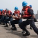 U.S. Sailors heave around on a line aboard USS Chung-Hoon