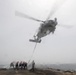 U.S. Sailors perform an inflight refueling with an MH-60R Sea Hawk on the flight deck of USS Spruance