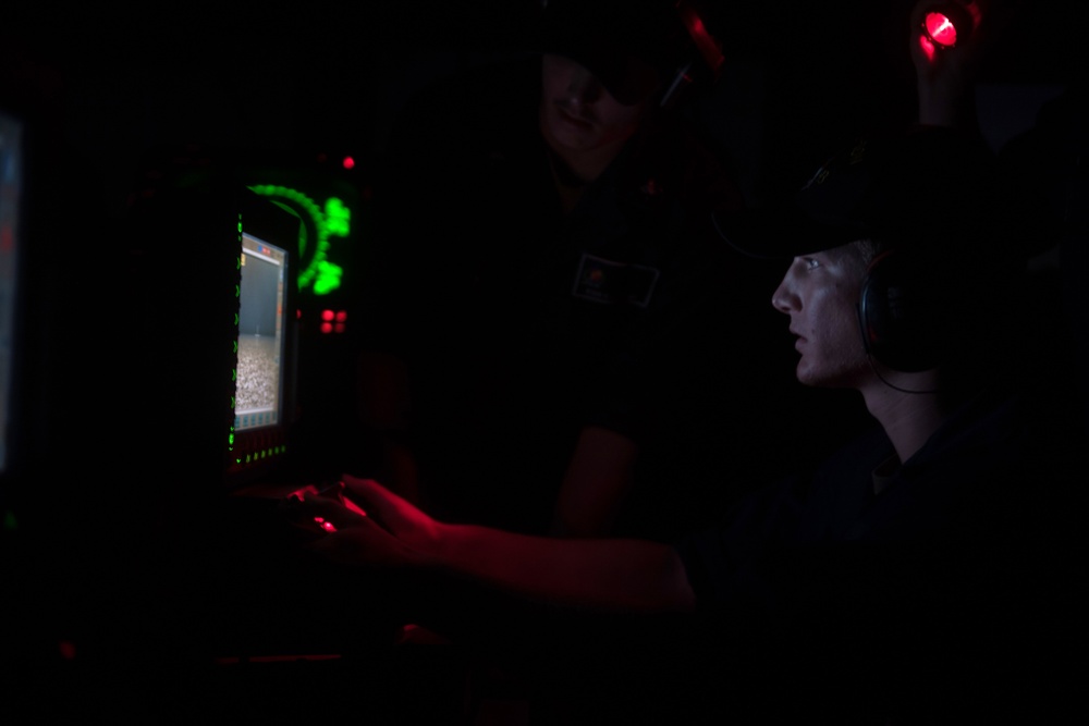 U.S. Navy Gunner’s Mate remotely fires a Mark 38 25mm machine gun system aboard USS Chung-Hoon