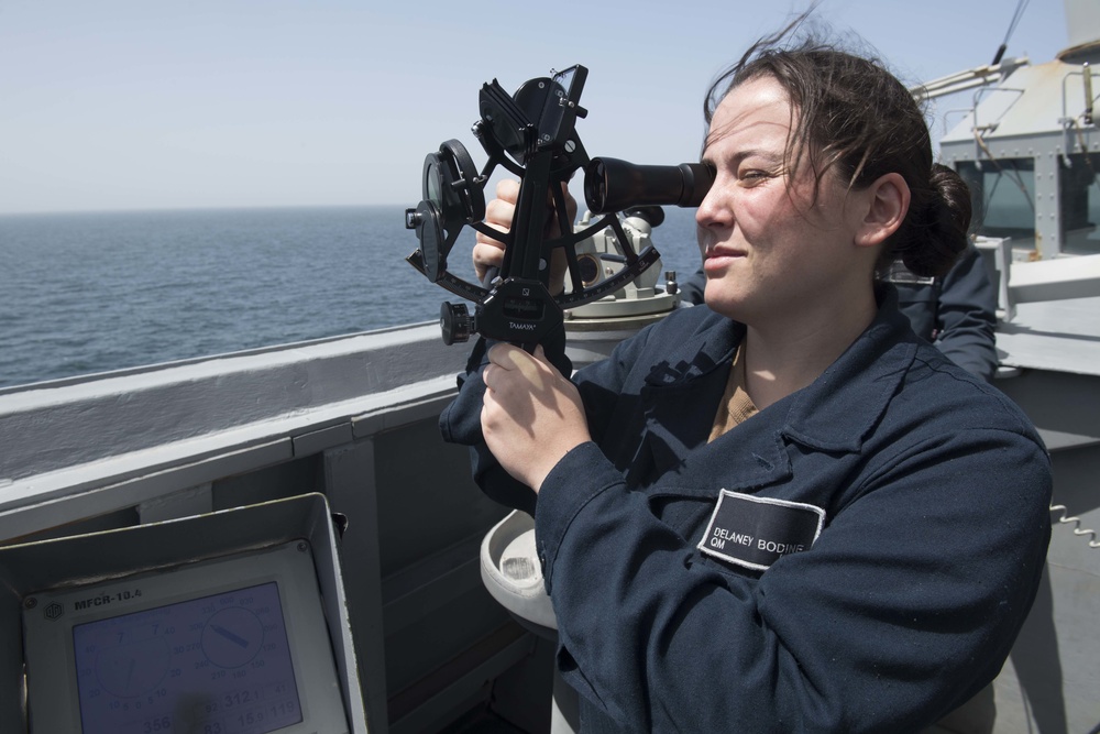 U.S. Navy Quarter Master Seaman uses a sextant aboard USS Spruance