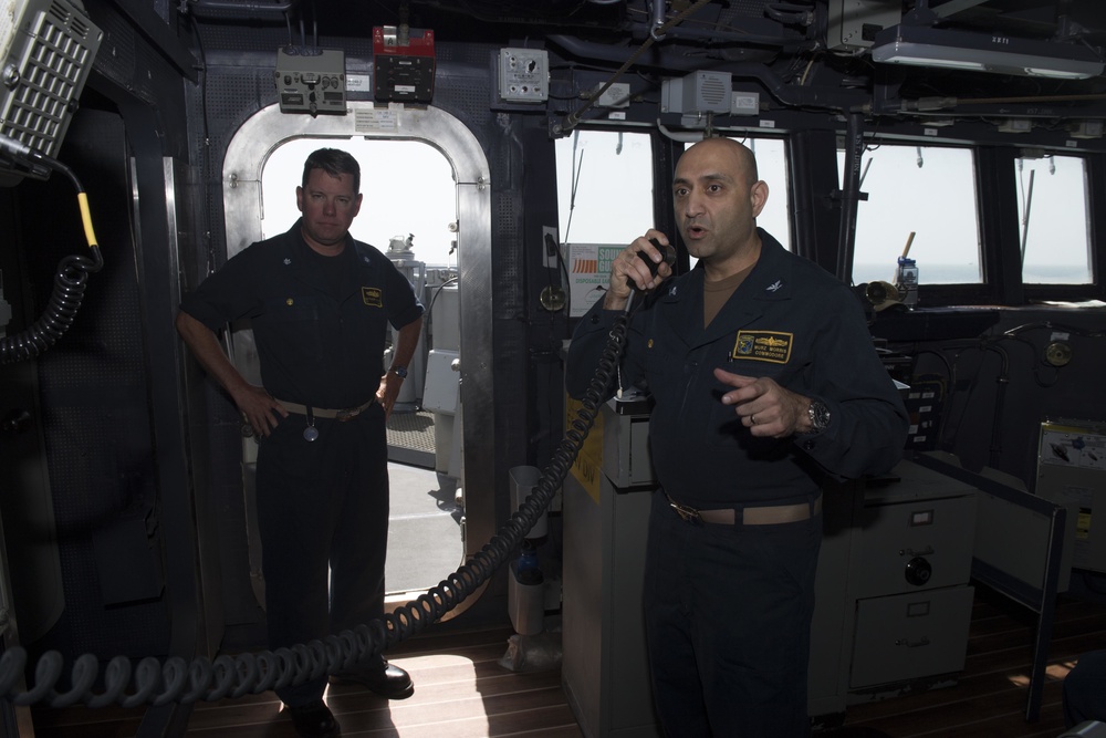 Commodore of Destroyer Squadron 21 uses the 1 main circuit (1MC) to address the crew aboard USS Spruance