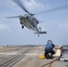 U.S. Navy Boatswain’s Mate prepares to chock and chain an MH-60S Sea Hawk