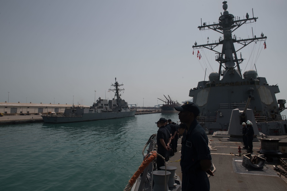 U.S. Sailors man the rails aboard the guided-missile destroyer USS Chung-Hoon (DDG 93) while entering Manama, Bahrain