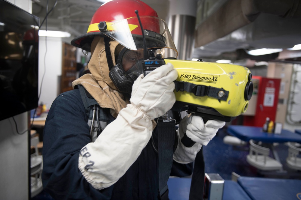 U.S. Navy Sailors respond to a simulated fire during a damage control training evolution aboard the guided-missile destroyer USS Spruance (DDG 111)