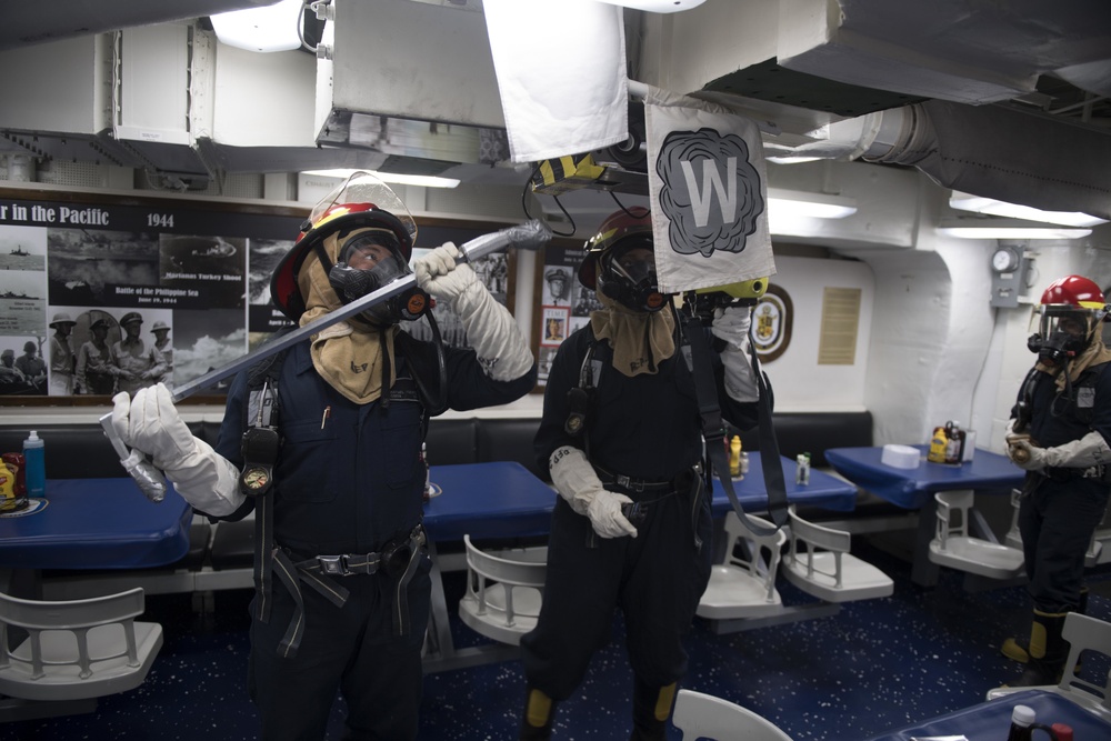 U.S. Navy Gunner’s Mate moves in to break up a hot spot during a damage control training evolution