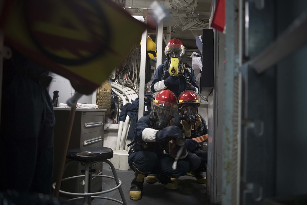 U.S. Navy Sailors engage simulated casualties during a general quarters drill aboard the USS Spruance.