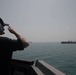 U.S. Navy Quartermaster salutes the fleet replenishment oiler USNS Kanawha