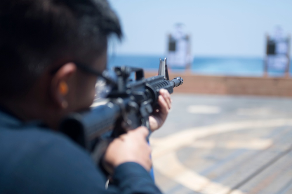 Quartermaster 3rd Class Vhlake Abangan, from Temecula, California, fires an M4 carbine rifle during a small arms weapons qualification aboard the USS Spruance (DDG 111).