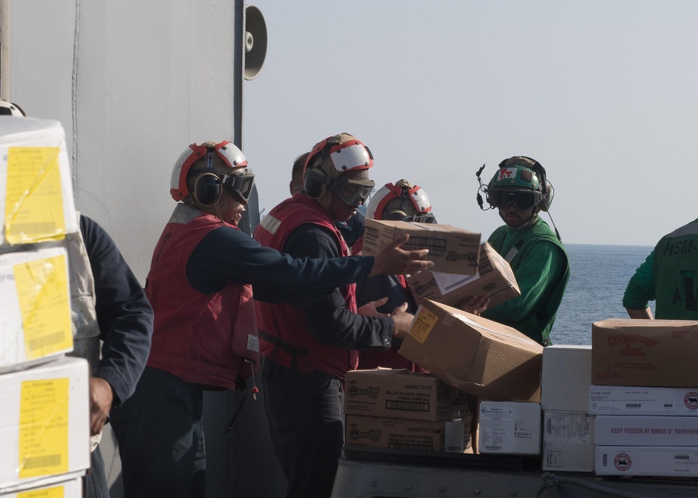 U.S. Sailors unload pallets during a replenishment-at-sea