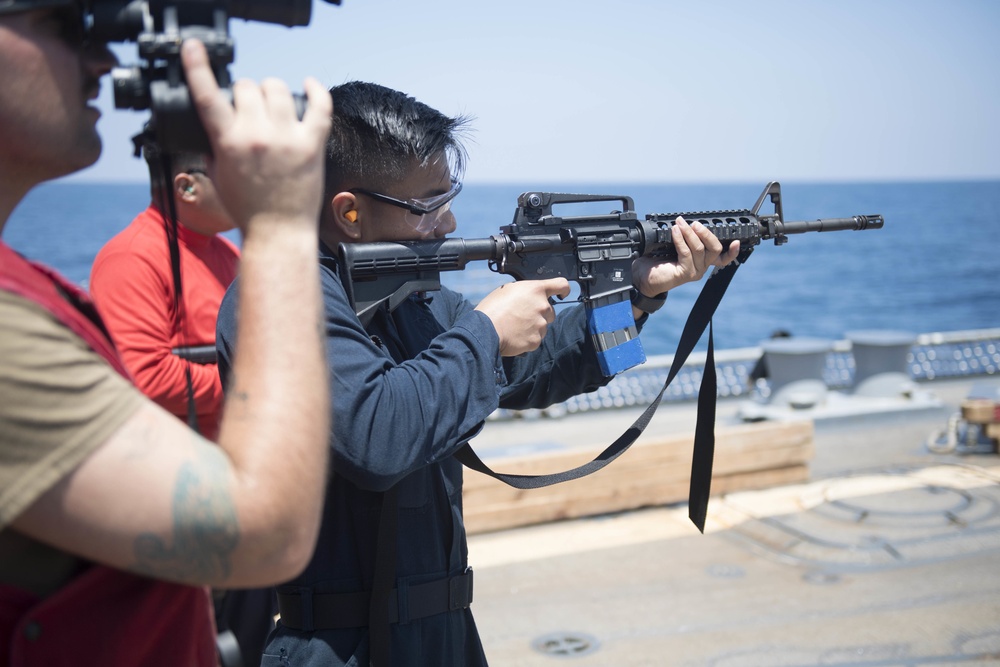 Quartermaster 3rd Class Vhlake Abangan, from Temecula, California, fires an M4 carbine rifle during a small arms weapons qualification aboard the USS Spruance (DDG 111).