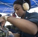 Interior Communications Specialist 2nd Class Ashanti Gilchrist, from Los Angeles, repairs a vital interior communications network aboard the guided-missile destroyer USS Spruance (DDG 111).