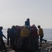 U.S. Sailors move pallets off the flight deck during a replenishment-at-sea