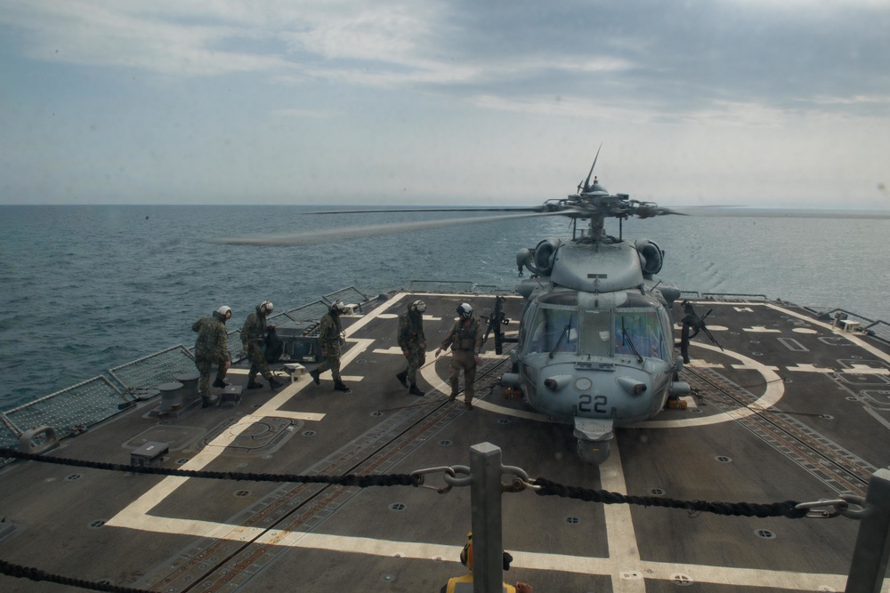 U.S. Sailors approach an MH-60S Sea Hawk helicopter on the flight deck of USS Stockdale