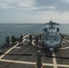 U.S. Sailors approach an MH-60S Sea Hawk helicopter on the flight deck of USS Stockdale