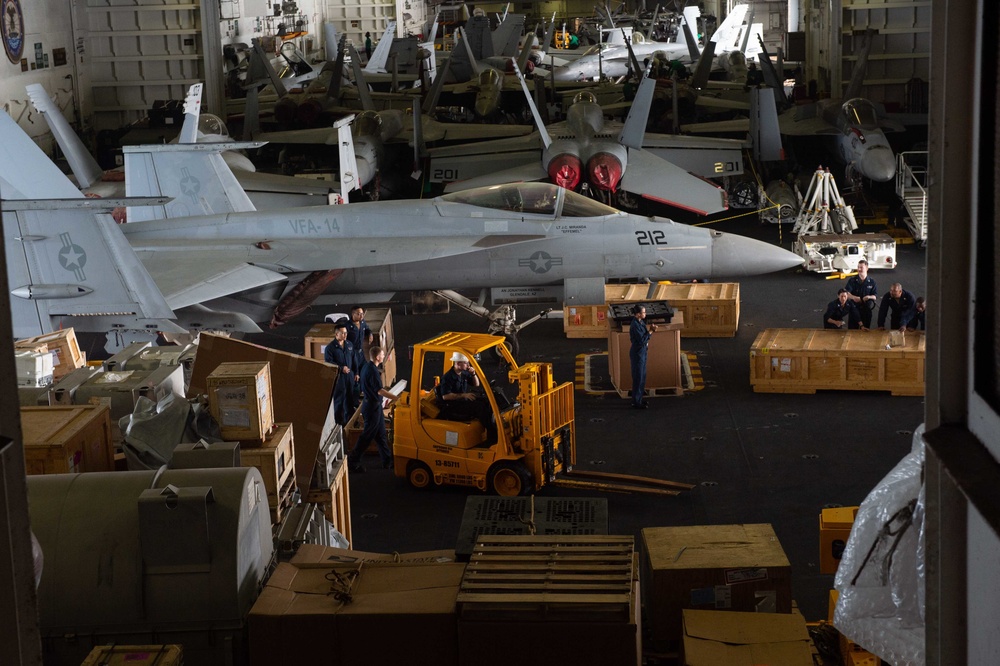 U.S. Sailors transport cargo in the hangar bay