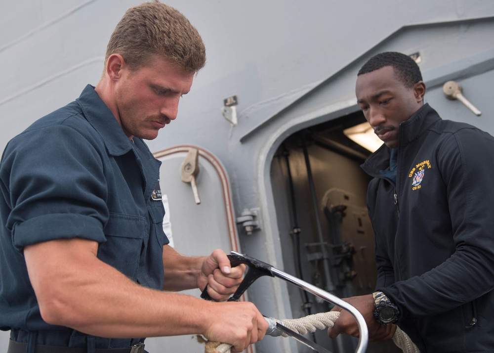 Sailors repair mooring lines aboard the guided-missile cruiser USS Mobile Bay