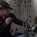U.S. Navy Chief Machinist Mate inspects a low pressure air compressor aboard USS Mobile Bay