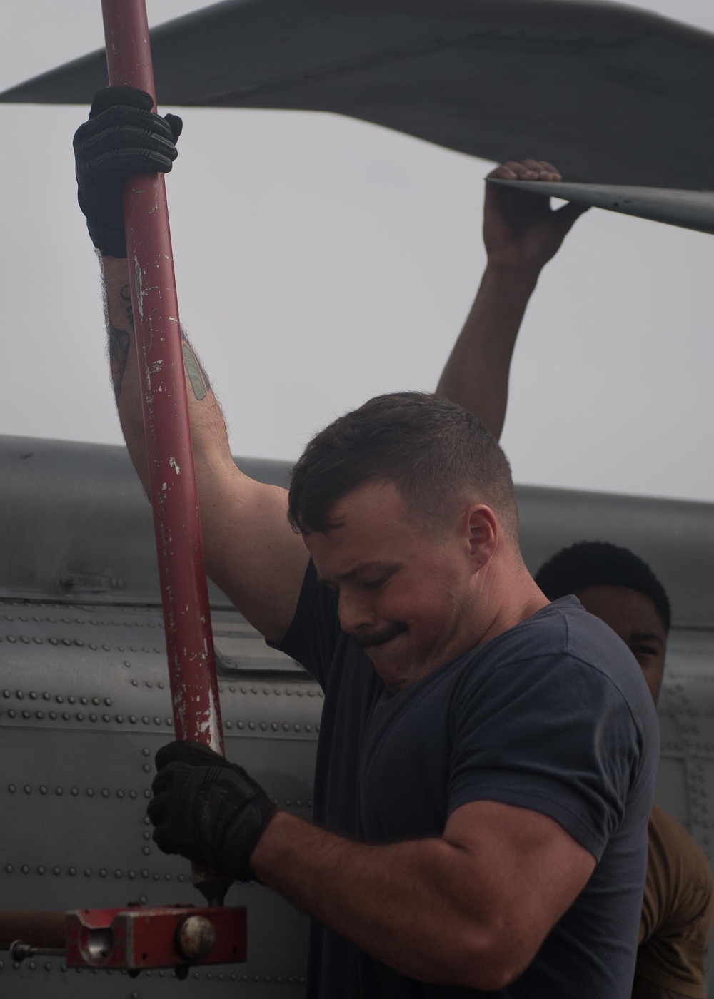 U.S Sailor installs support crutches for the rotor wings on an MH-60R Sea Hawk