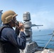 U.S. Sailor talks to the gunnery control officer during a live-fire exercise