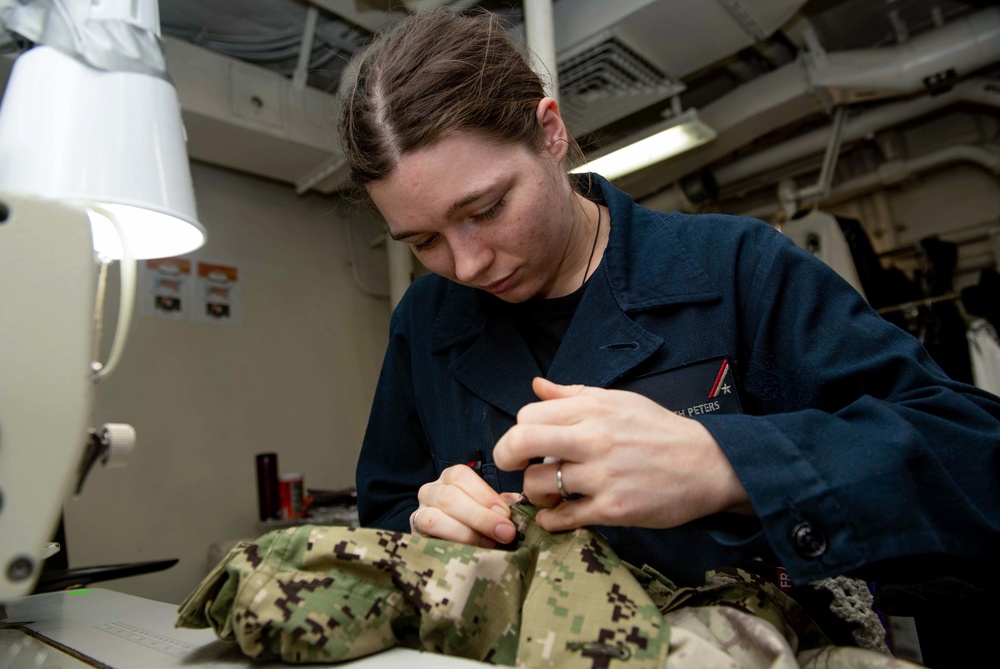 U.S. Sailor alters a uniform