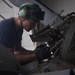 U.S. Sailor removes a drive shaft on an MH-60R Sea Hawk
