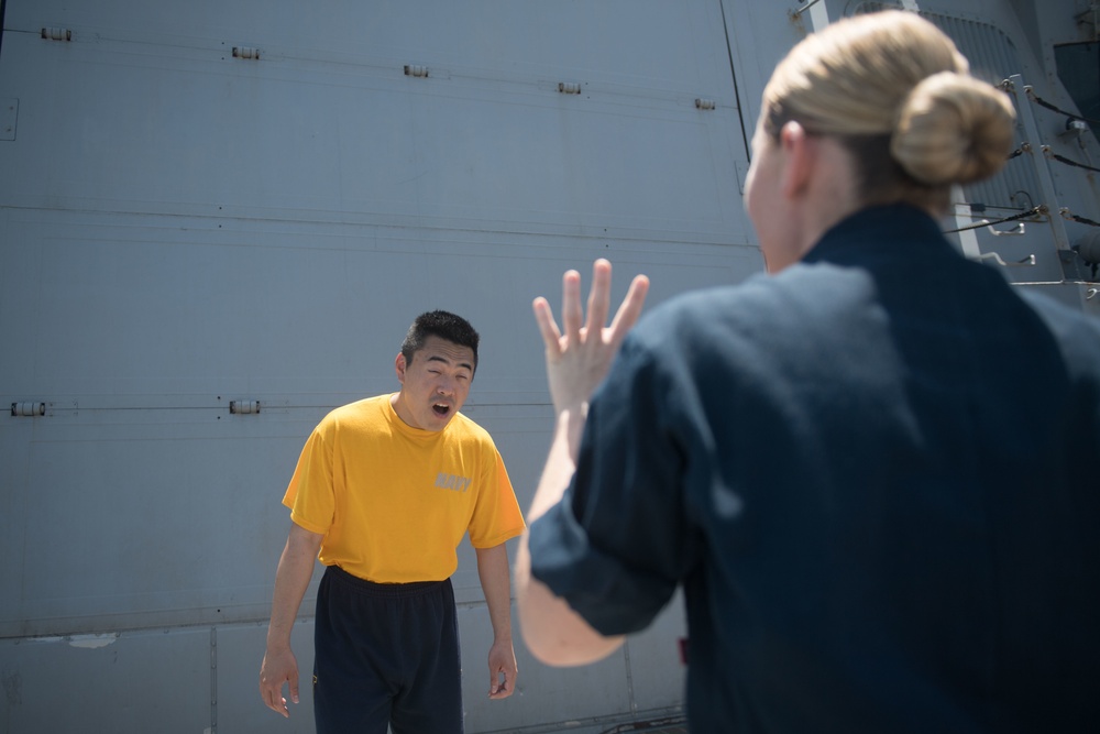 U.S. Sailor gets sprayed with oleoresin capsicum spray during security reaction force basic training aboard USS Stockdale