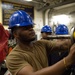 U.S. Sailor conducts maintenance on a jet engine
