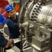 U.S. Sailors conducts maintenance on a jet engine