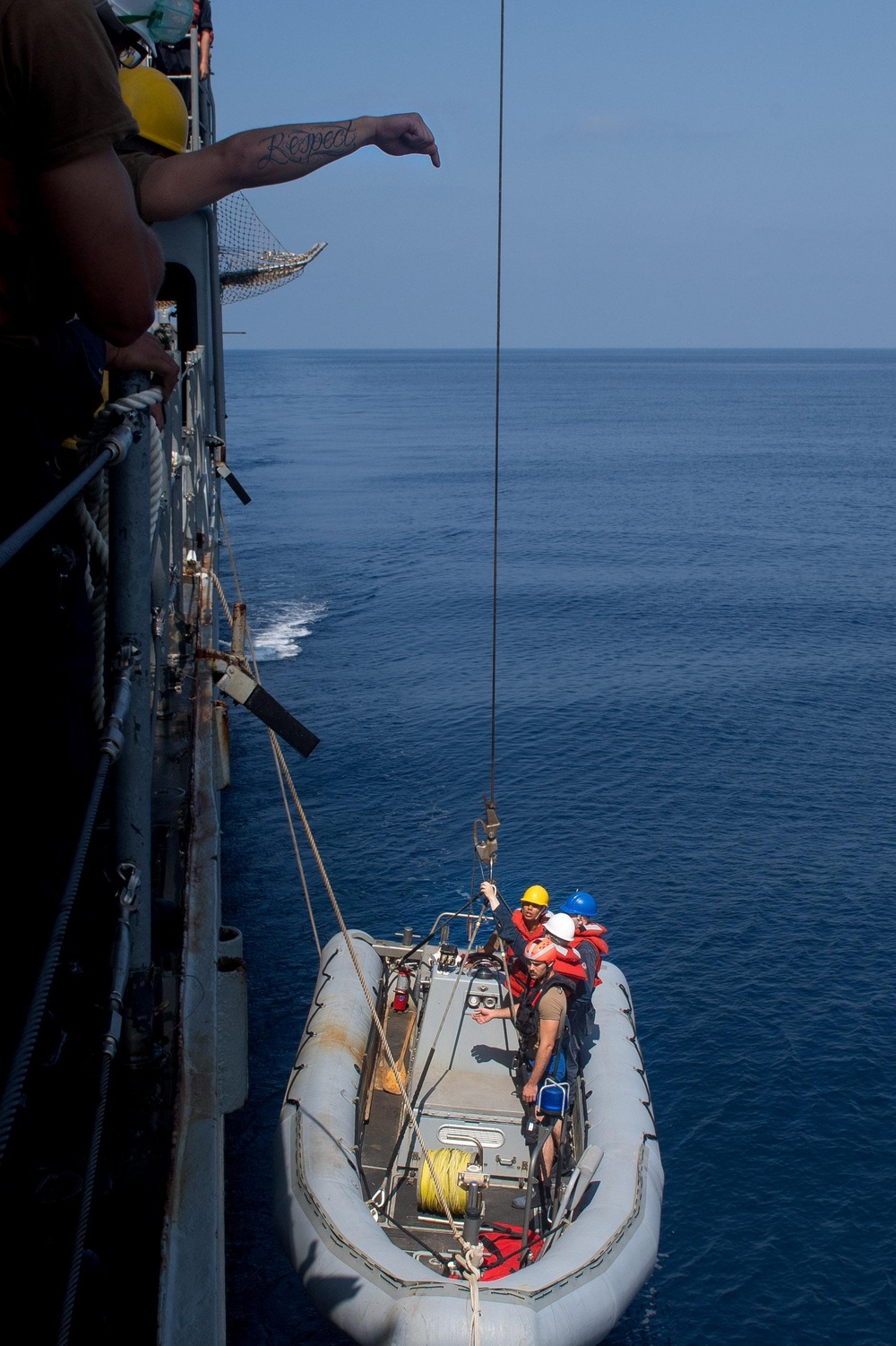 U.S. Sailors lower a rigid-hull inflatable boat for small boat operations from USS Mobile Bay
