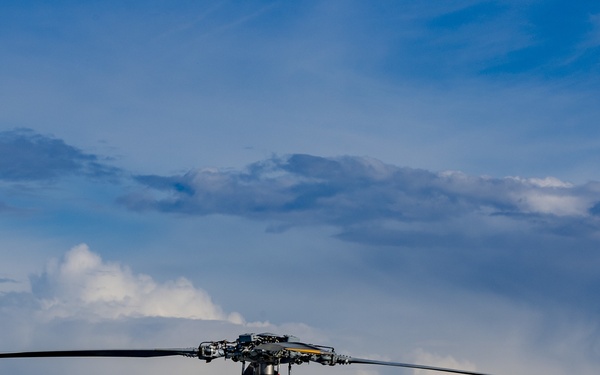 A MH-60S search and rescue helicopter sits near an EA-18G Growler.
