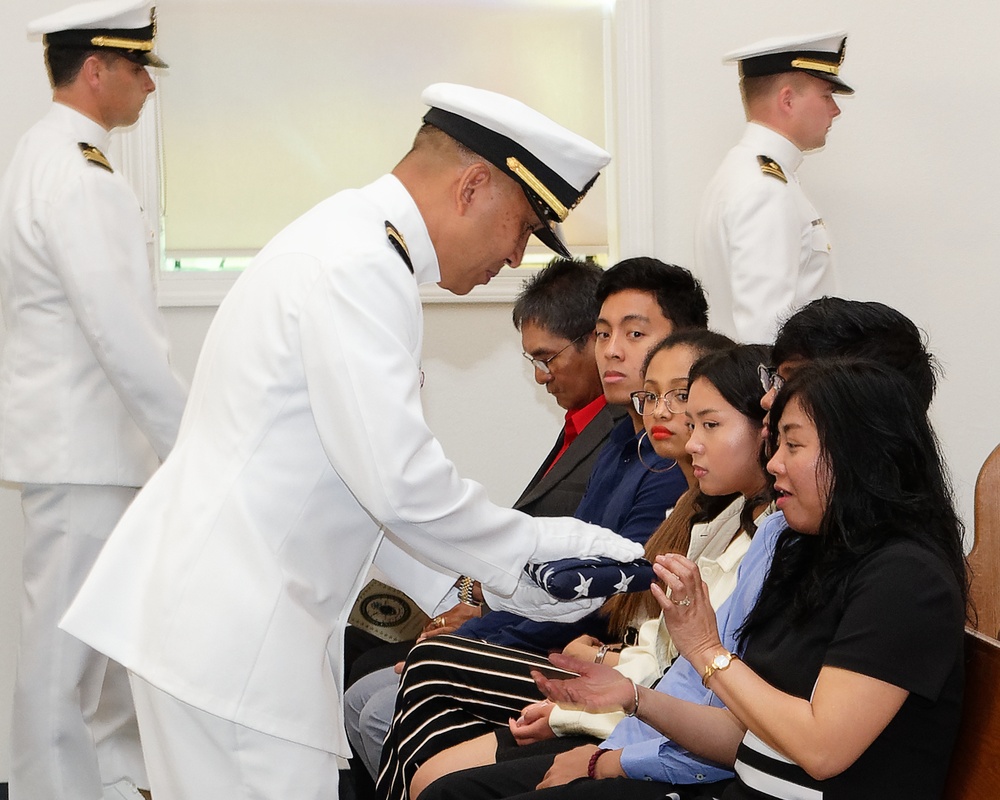 Lt. Cmdr. Felix Villanueva gives the flag to his wife