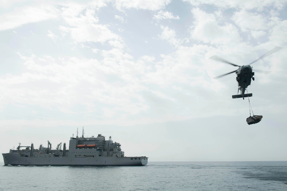 An MH-60S Sea Hawk transfers cargo to the guided-missile destroyer USS Spruance