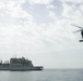 An MH-60S Sea Hawk transfers cargo to the guided-missile destroyer USS Spruance