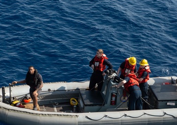 U. S. Sailors operating a Ridged Hull Inflatable Boat (RHIB) prepare to pull alongside