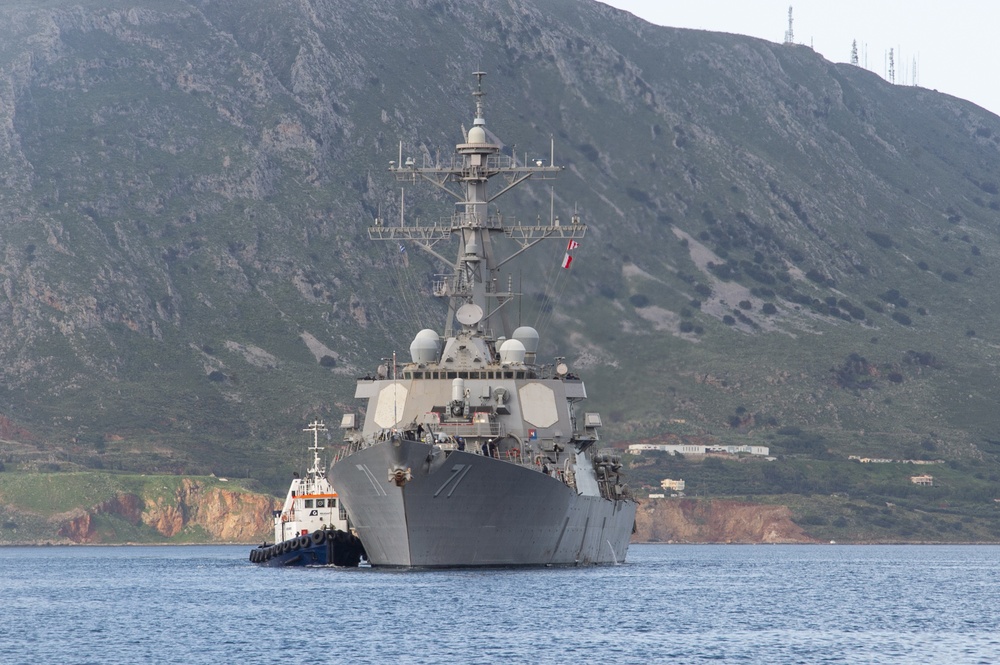 A tug boat from Naval Support Activity (NSA) Souda Bay port operations assists the Arleigh Burke-class guided-missile destroyer USS Ross (DDG 71) as it arrives in Souda Bay, Greece, for a scheduled port visit, April 12, 2019.