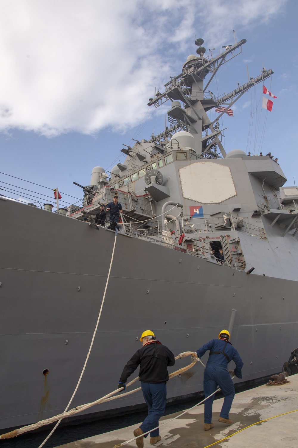 Naval Support Activity (NSA) Souda Bay port operations line handlers heave a mooring line as the Arleigh Burke-class guided-missile destroyer USS Ross (DDG 71) moors pierside at Souda Bay, Greece, April 12, 2019.