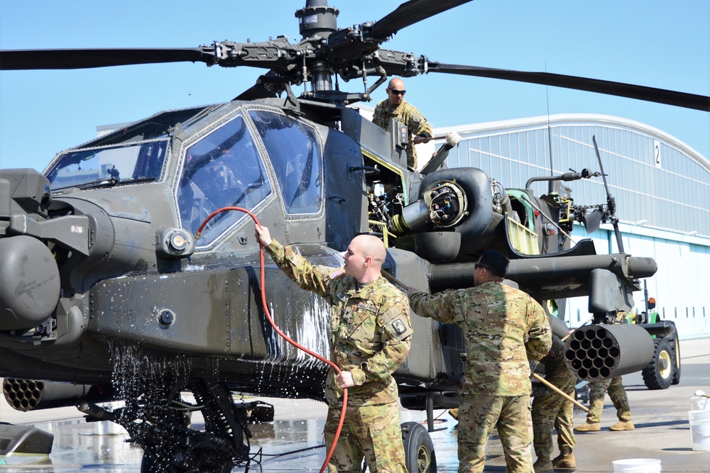 Soldier washing Apache helicopter. 