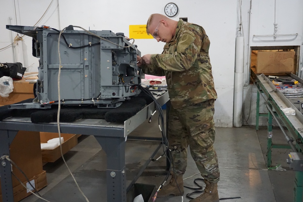 Senior Airman Cody Vanoosten, 56th Component and Maintenance Squadron, Luke Air Force Base, Arizona, disassembles an Advanced Concept Ejection Seat at Letterkenny Munitions Center.