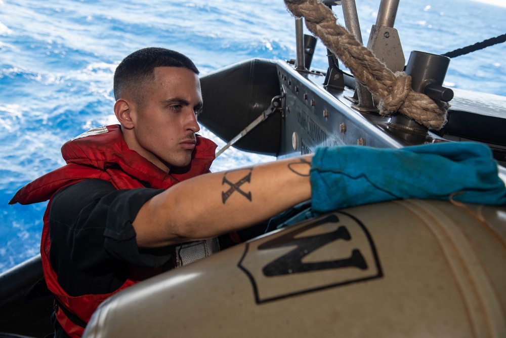 U.S. Sailor cleans a rigid-hull inflatable boat