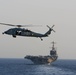 An MH-60S Sea Hawk hovers in front of USS John C. Stennis in the Red Sea