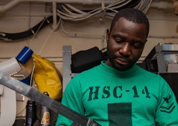 U.S. Sailor conducts maintenance on a search and rescue radio device