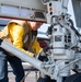 U.S. Sailor secures a chain to an F/A-18E Super Hornet